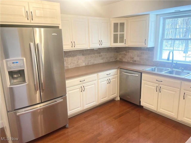 kitchen with decorative backsplash, white cabinetry, sink, and appliances with stainless steel finishes