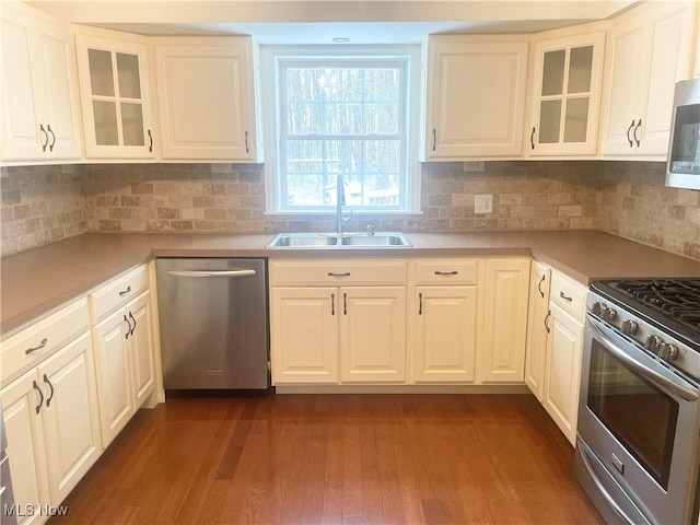 kitchen featuring decorative backsplash, sink, white cabinets, and stainless steel appliances