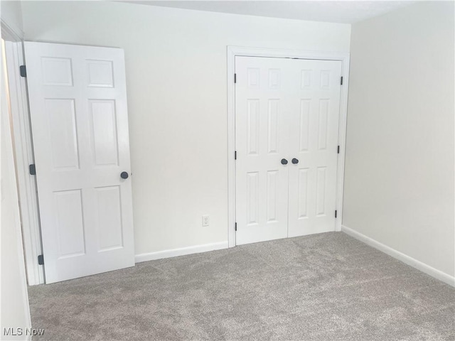 unfurnished bedroom featuring carpet and a closet