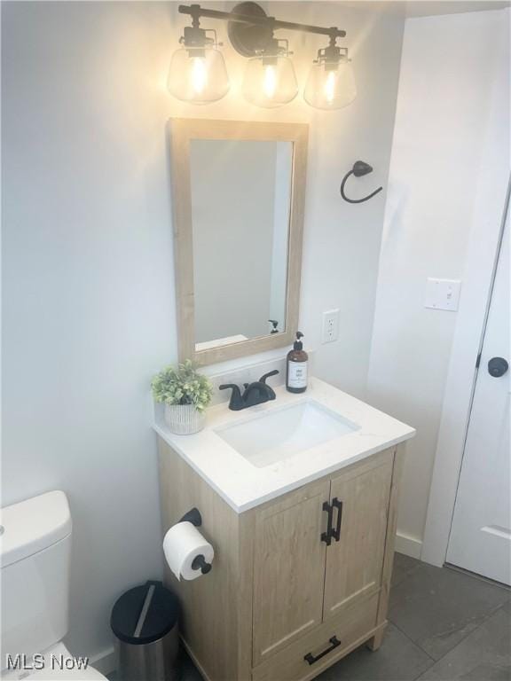 bathroom featuring tile patterned floors, vanity, and toilet