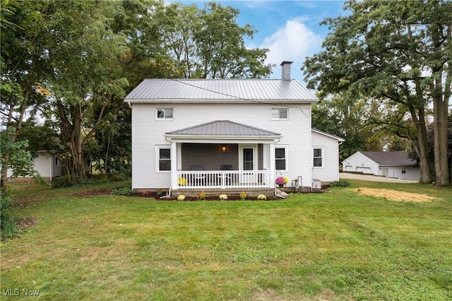 back of house featuring a lawn and a porch