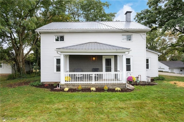 back of property with covered porch and a yard