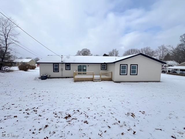 snow covered rear of property featuring a wooden deck