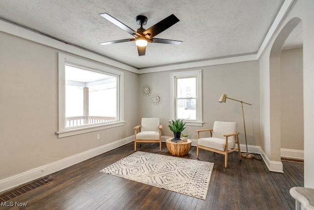 living area with dark hardwood / wood-style flooring, a textured ceiling, and ceiling fan