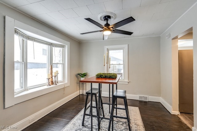 dining space featuring dark hardwood / wood-style floors, ceiling fan, and crown molding