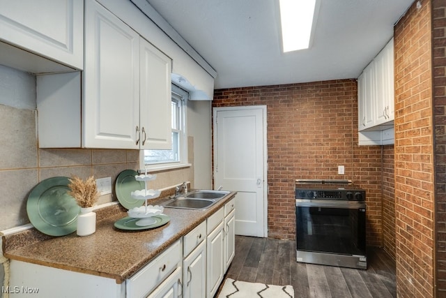 kitchen with white cabinetry, sink, and stainless steel range oven