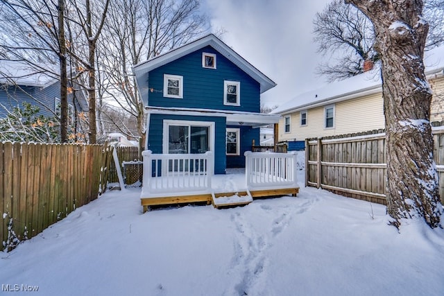 snow covered house with a deck