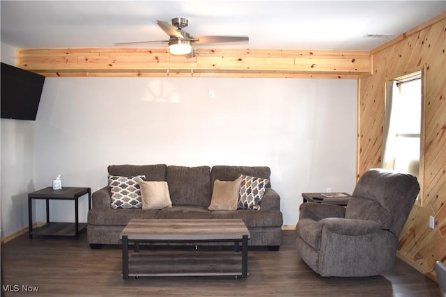 living room featuring wood walls, ceiling fan, and dark wood-type flooring