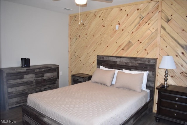 bedroom with wood walls and ceiling fan