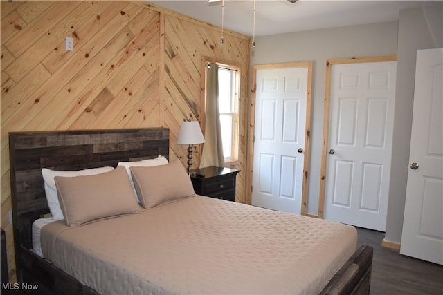 bedroom featuring dark hardwood / wood-style floors and wood walls