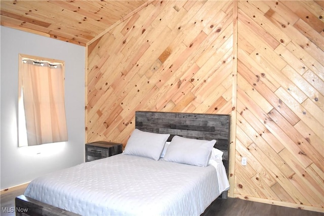 bedroom featuring dark hardwood / wood-style floors, wood ceiling, and wooden walls