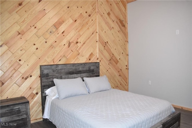 bedroom featuring wood walls