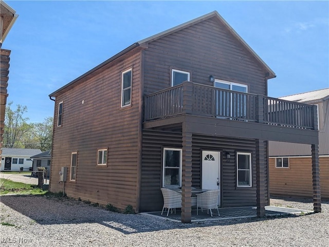 rear view of property with a patio and a balcony