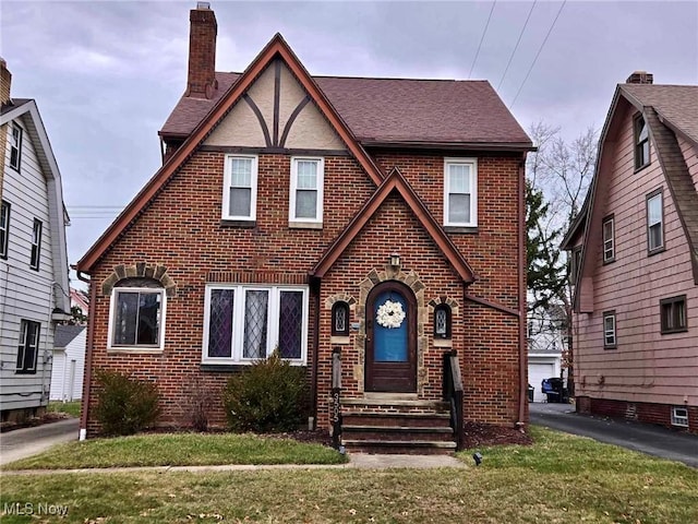 tudor-style house featuring a front yard