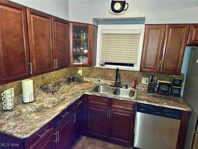 kitchen with sink, light stone counters, decorative backsplash, light tile patterned floors, and appliances with stainless steel finishes