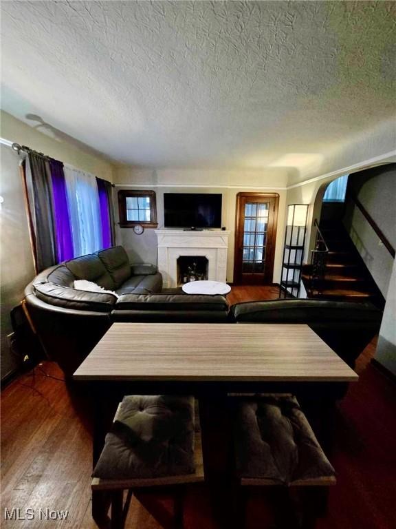 living room with hardwood / wood-style floors, a healthy amount of sunlight, and a textured ceiling