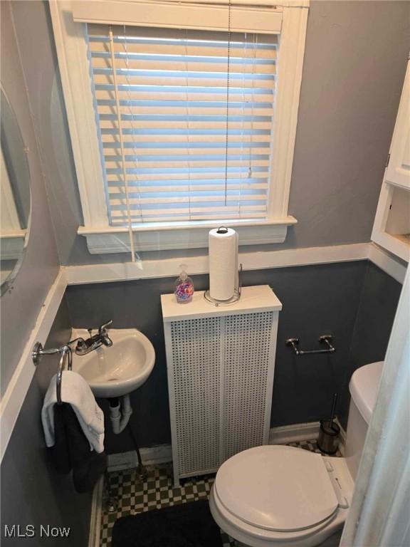 bathroom featuring toilet, radiator, and sink