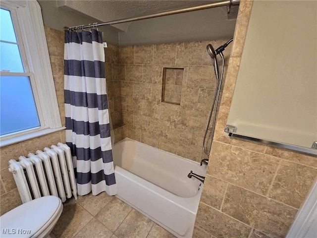 bathroom featuring a wealth of natural light, radiator heating unit, shower / bathtub combination with curtain, and toilet