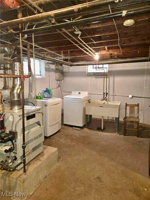 basement featuring washer and clothes dryer and sink