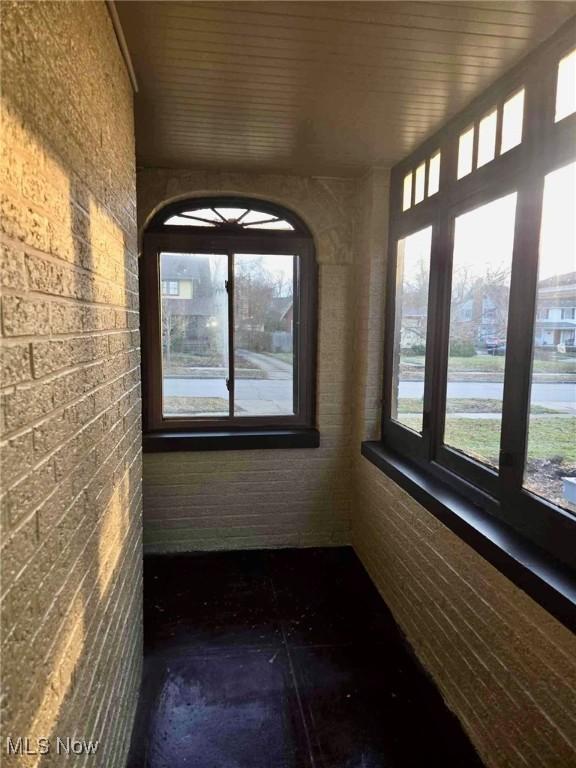 unfurnished sunroom featuring a healthy amount of sunlight and wooden ceiling