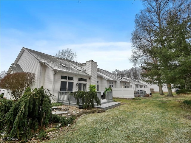 back of property featuring a deck and a yard