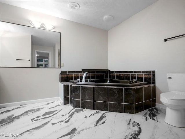 bathroom with toilet and tiled tub