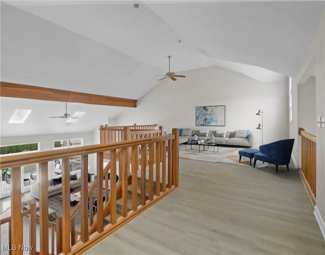 corridor featuring light wood-type flooring and lofted ceiling with skylight