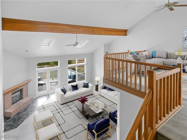 living room featuring a brick fireplace, lofted ceiling with skylight, and ceiling fan