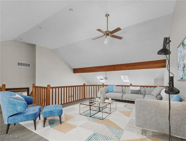 living room featuring ceiling fan and vaulted ceiling with skylight