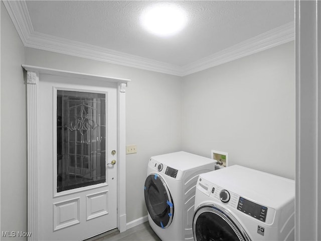 laundry area featuring crown molding, washing machine and dryer, and a textured ceiling