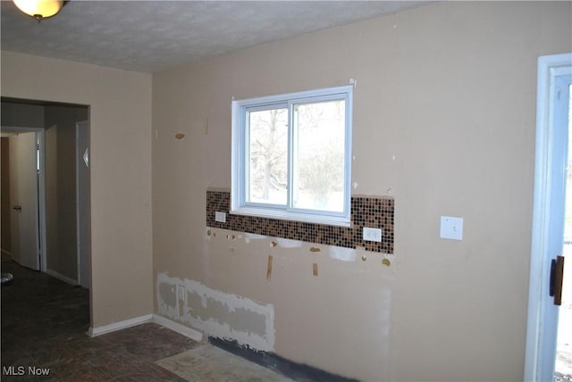 unfurnished room featuring a textured ceiling