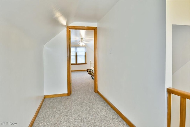 hallway featuring light colored carpet and lofted ceiling