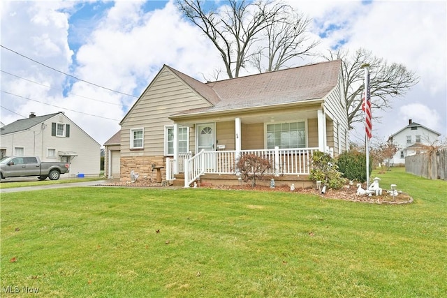 view of front of property with a porch, a garage, and a front lawn