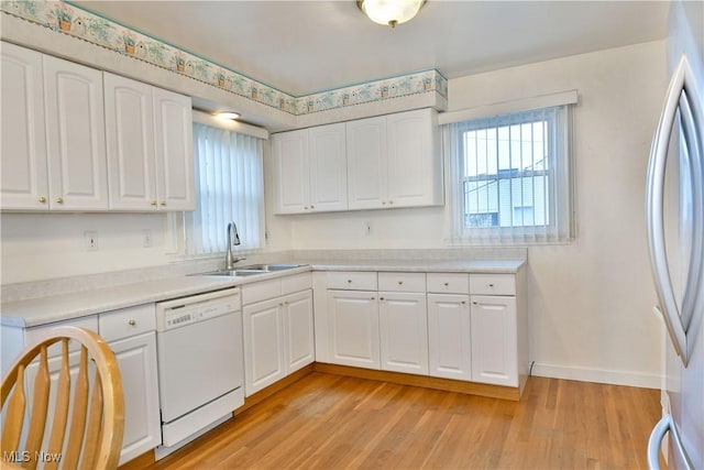 kitchen featuring sink, white cabinets, white appliances, and light hardwood / wood-style flooring