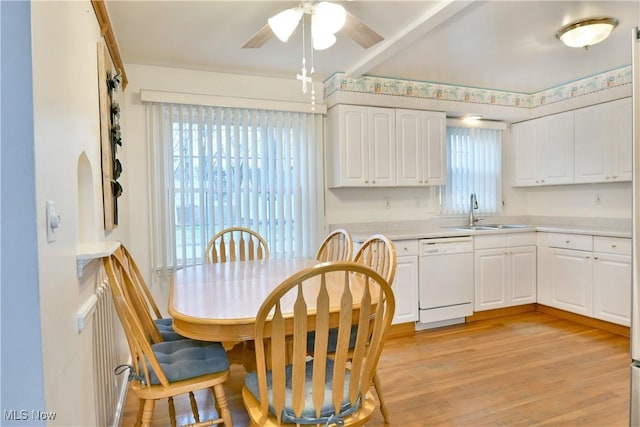 kitchen featuring sink, a healthy amount of sunlight, light hardwood / wood-style flooring, white dishwasher, and white cabinets