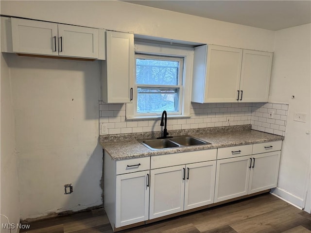 kitchen featuring tasteful backsplash, sink, and white cabinets