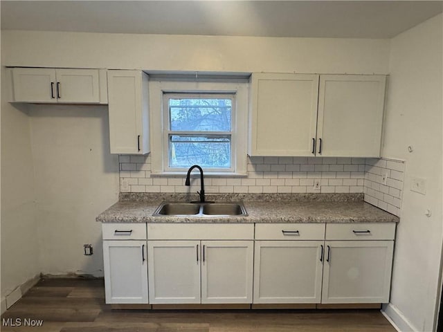 kitchen with decorative backsplash, sink, white cabinets, and dark wood-type flooring