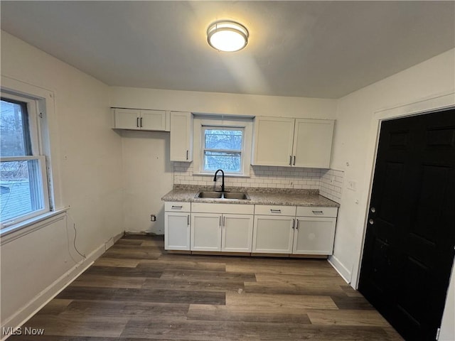 kitchen with white cabinets, decorative backsplash, dark hardwood / wood-style flooring, and sink