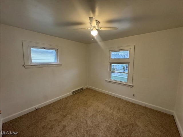 carpeted spare room with ceiling fan