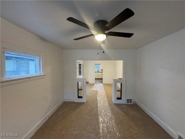 carpeted spare room with ceiling fan