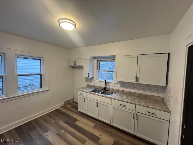 kitchen featuring white cabinets, backsplash, sink, and dark wood-type flooring