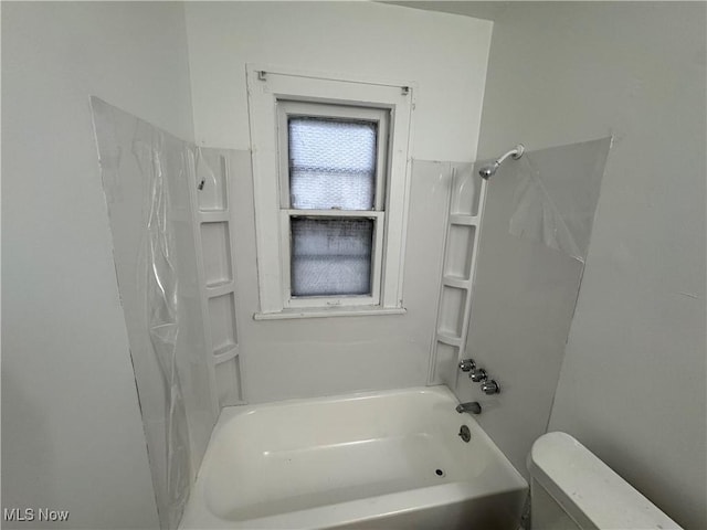 bathroom featuring toilet and bathing tub / shower combination