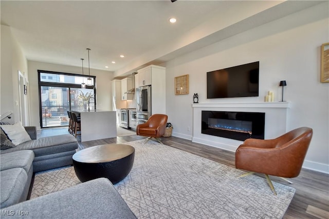 living area featuring recessed lighting, wood finished floors, and baseboards