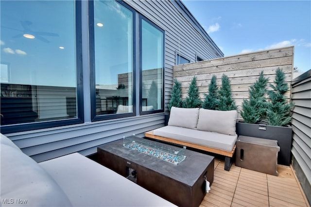 balcony with an outdoor living space with a fire pit