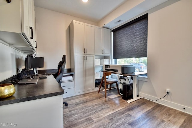 home office featuring light wood-type flooring, baseboards, and visible vents
