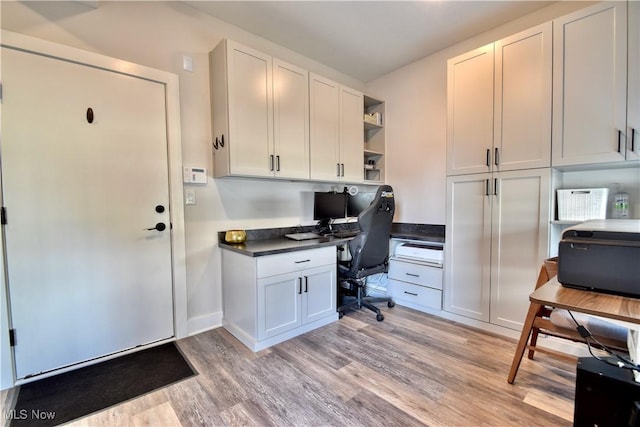 office space featuring light wood finished floors and built in desk