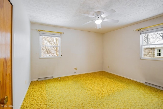 unfurnished room featuring carpet flooring, baseboard heating, a healthy amount of sunlight, and ceiling fan