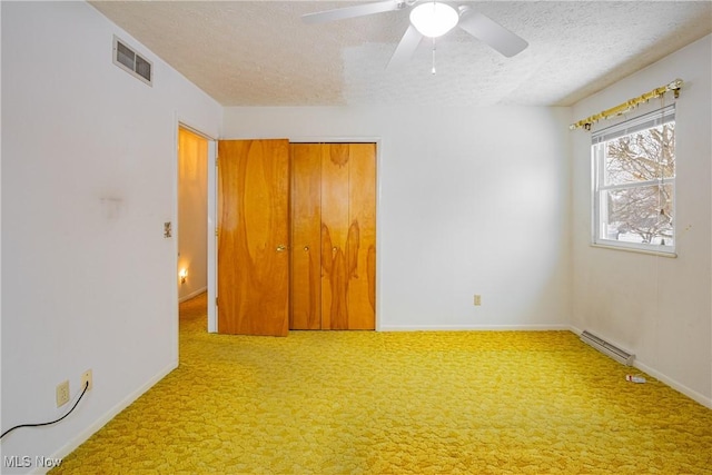 unfurnished bedroom with ceiling fan, a closet, carpet, and a textured ceiling