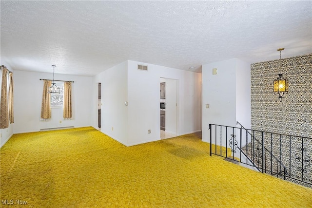 unfurnished room featuring carpet flooring, a textured ceiling, and a baseboard radiator