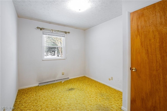 carpeted empty room featuring a textured ceiling and a baseboard heating unit